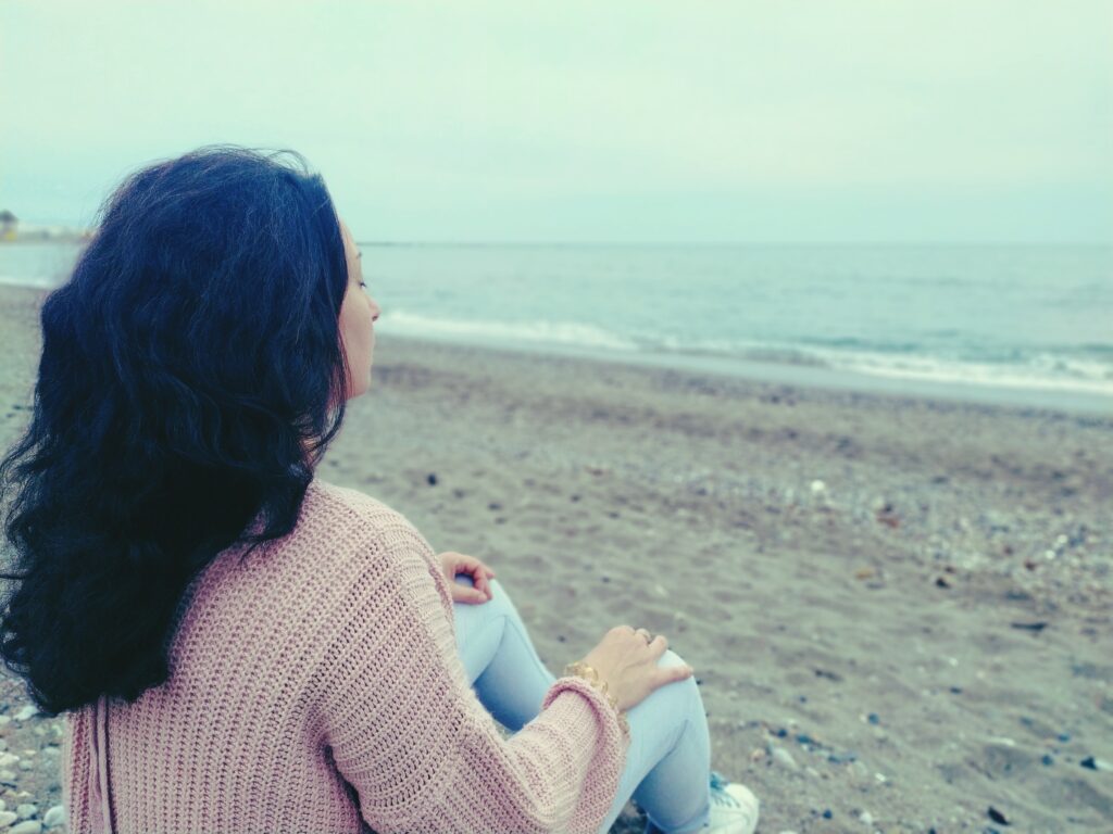 Foto de la biografía de la escritora Juana Álvarez Durán durante una meditación en la playa